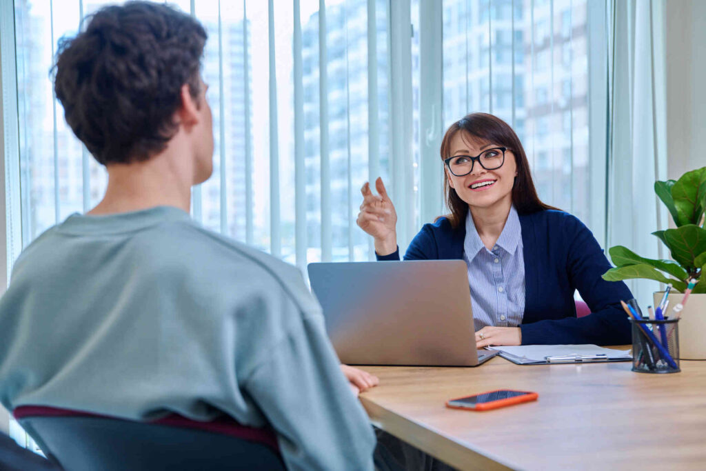guy student at therapy meeting with psychologist, mentor in college office